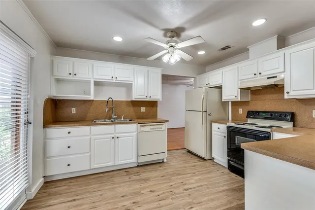 a kitchen with white cabinets and stainless steel appliances