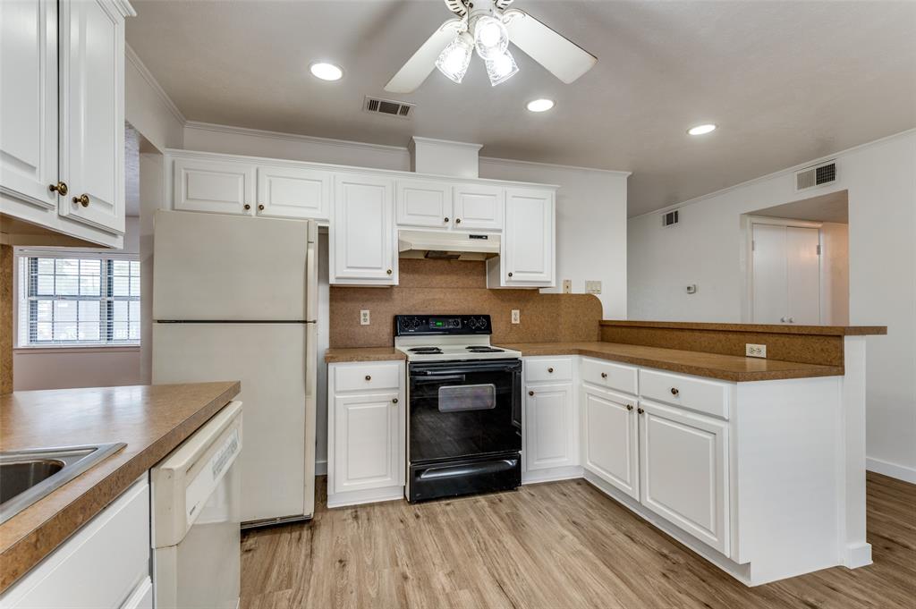 1230 Fairdale Street Irving, TX 75062 - Photo 8 of 24 Kitchen with recessed lighting, white appliances, white cabinetry, light wood-style floors, and crown molding