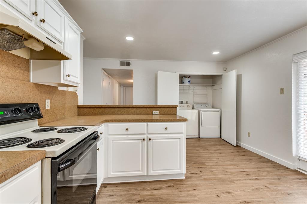 1230 Fairdale Street Irving, TX 75062 - Photo 9 of 24 Kitchen featuring black range with electric stovetop, under cabinet range hood, backsplash, white cabinetry, and light countertops