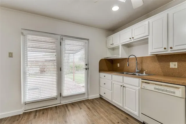 a kitchen with granite countertop white cabinets and white appliances