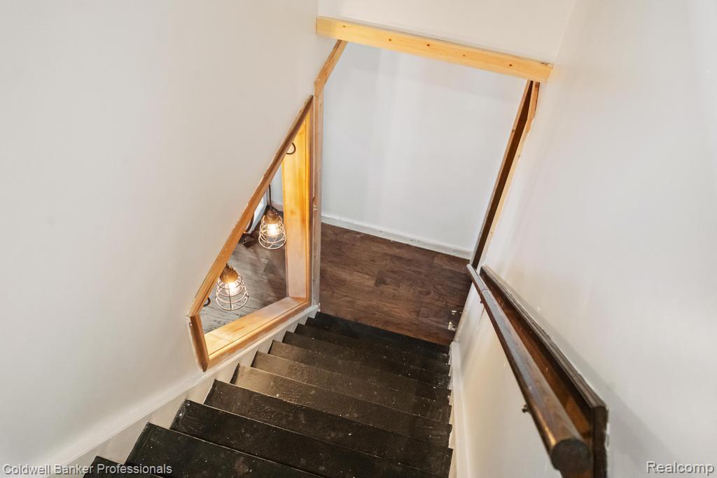 6389 Postlewait Road Mancelona, MI 49659 - Photo 32 of 50 Staircase featuring wood-finish treads, a wood handrail, and white walls