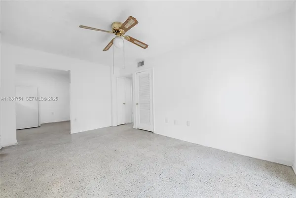 an empty room with a ceiling fan and a window