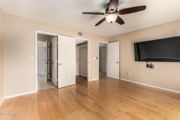 a view of a livingroom with a flat screen tv wooden floor and a ceiling fan