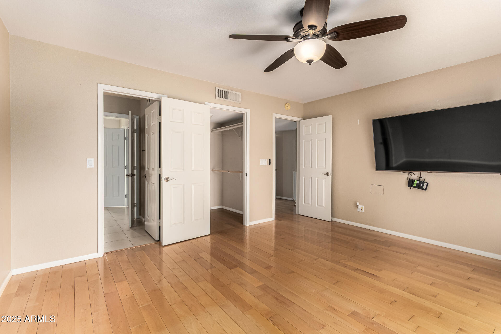 11615 North 40th Way Phoenix, AZ 85028 - Photo 17 of 34 a view of a livingroom with a flat screen tv wooden floor and a ceiling fan