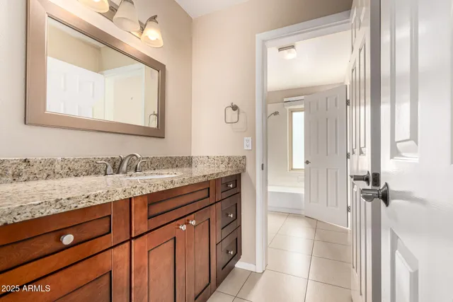 a bathroom with a granite countertop sink and a mirror