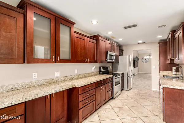 a kitchen with stainless steel appliances granite countertop a sink stove and cabinets