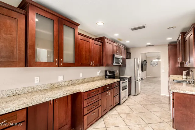 a kitchen with stainless steel appliances granite countertop a sink stove and cabinets