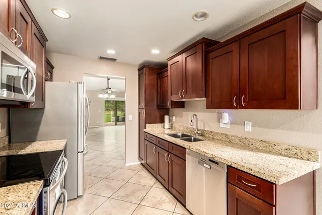 a kitchen with stainless steel appliances granite countertop a stove a sink and a microwave