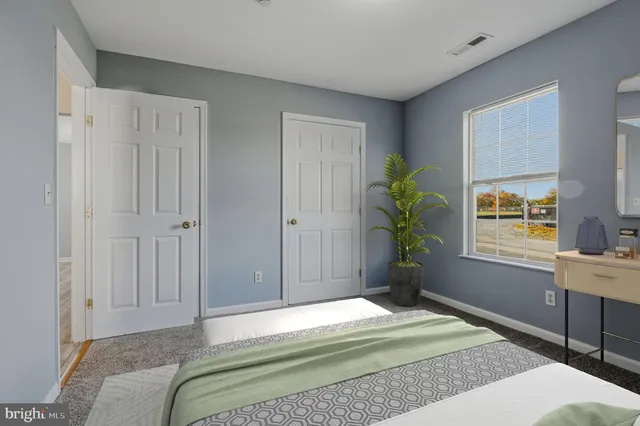 a bedroom with a bed potted plant on the dresser and chandelier