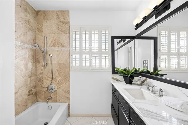 a bathroom with a granite countertop sink and a bathtub