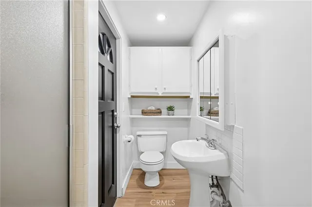 a bathroom with a toilet a sink and a mirror