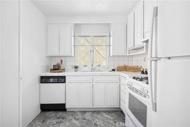 a kitchen with white cabinets and white appliances