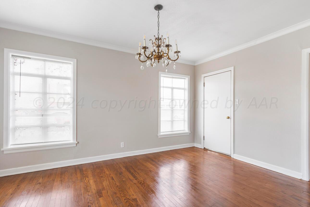 1026 Sunset Terrace Amarillo, TX 79106 - Photo 12 of 44 a view of an empty room with a window and wooden floor