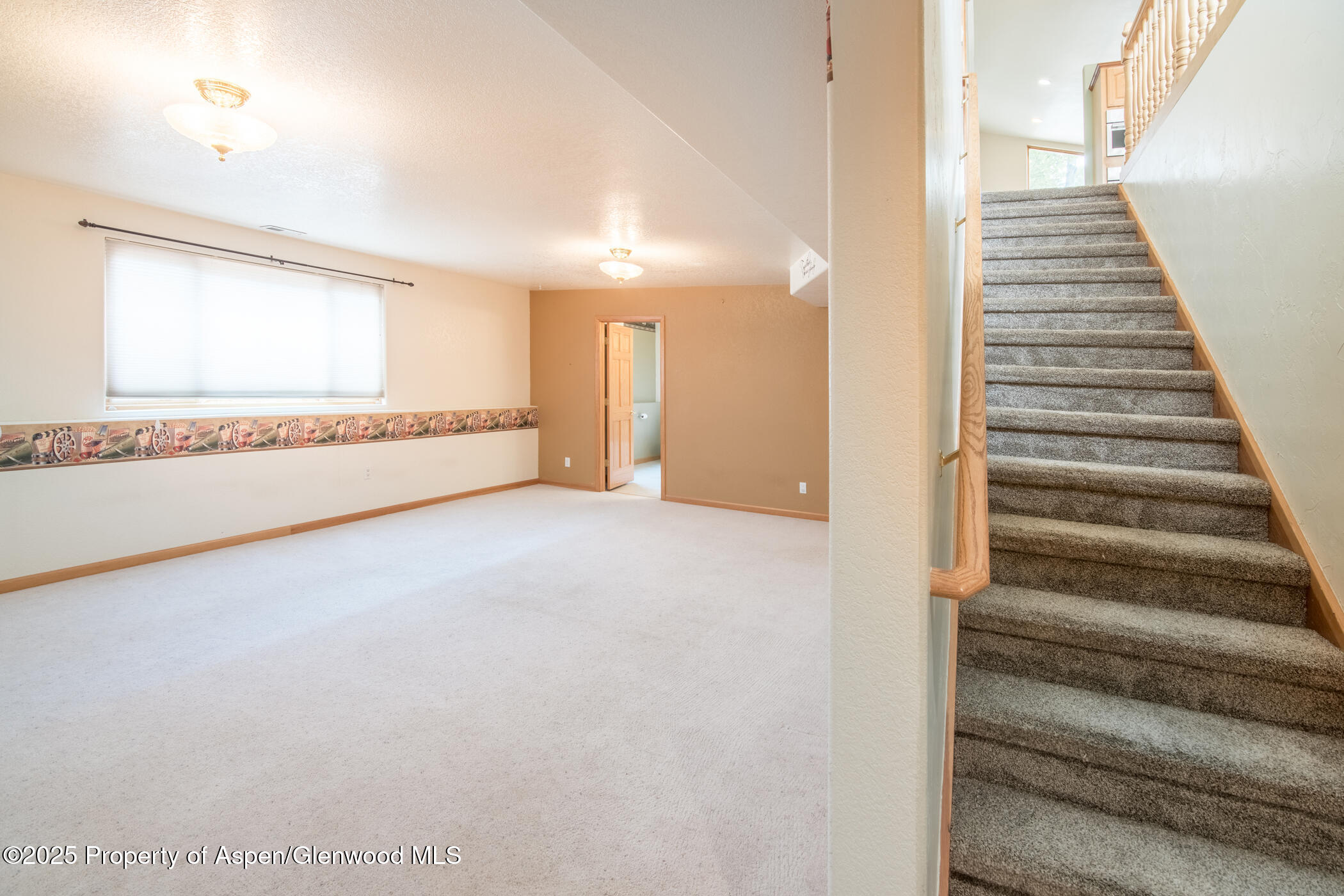 1230 Fir Avenue Rifle, CO 81650 - Photo 21 of 34 a view of an empty room with stairs and a window