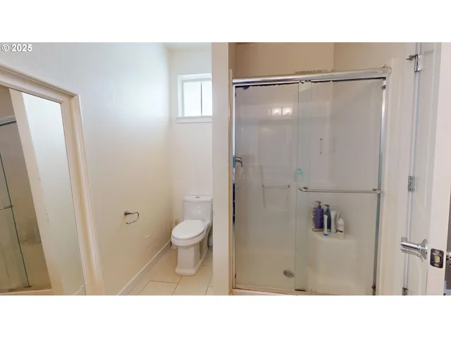 a bathroom with a toilet and a shower