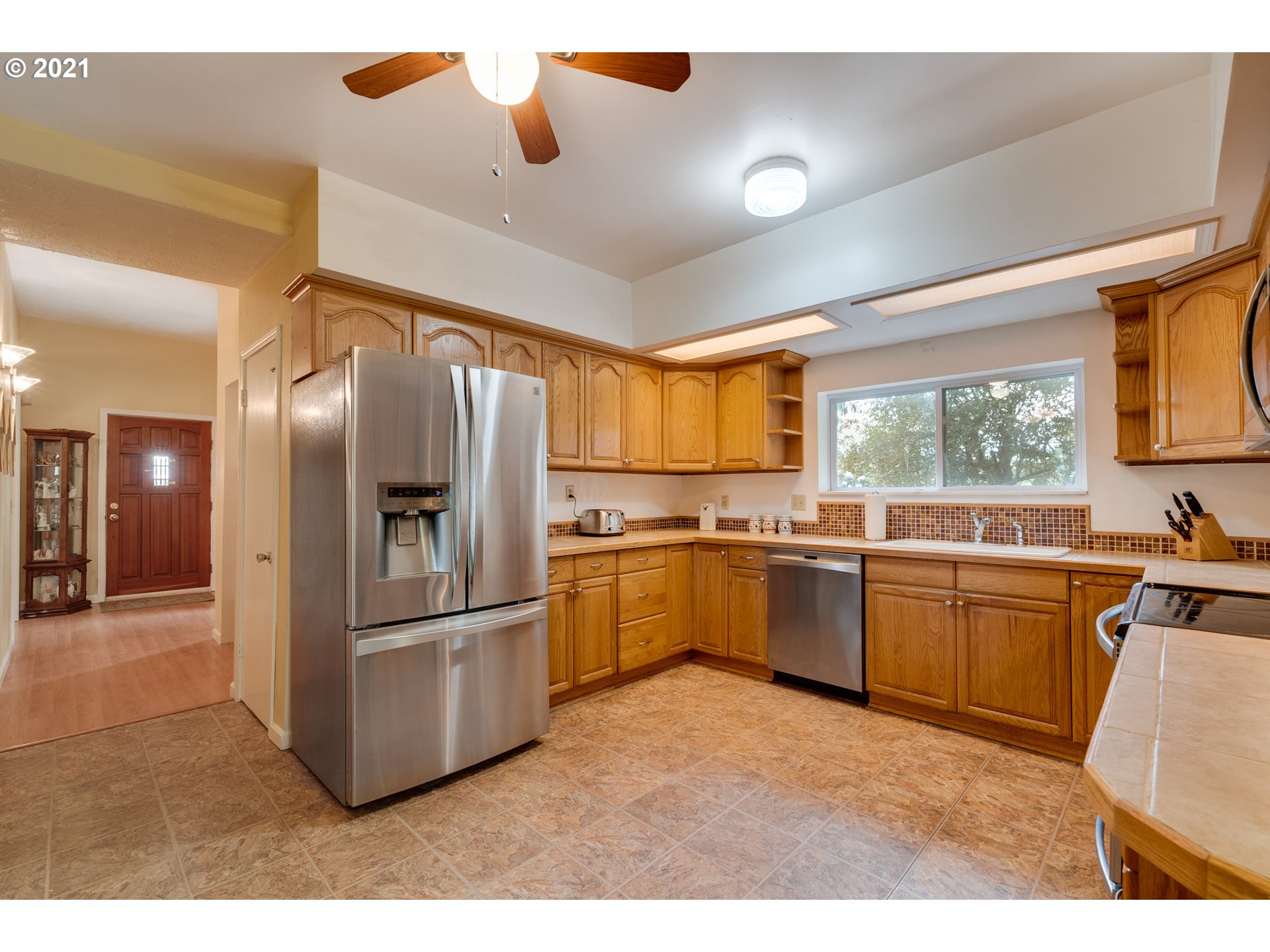 2559 Southwest Dilley Road Forest Grove, OR 97116 - Photo 12 of 32 a kitchen with granite countertop a refrigerator and white cabinets