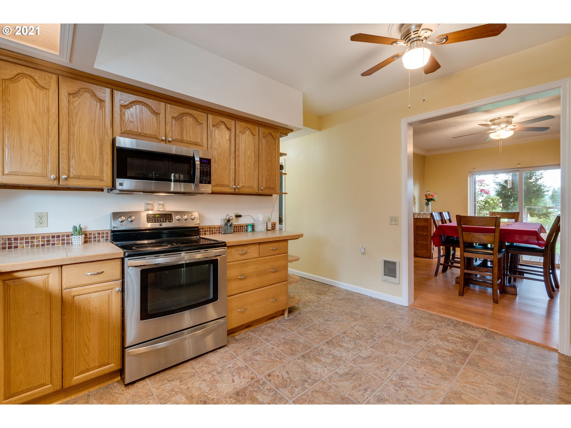 2559 Southwest Dilley Road Forest Grove, OR 97116 - Photo 14 of 32 a kitchen with stainless steel appliances granite countertop a stove top oven a sink dishwasher a dining table and chairs with wooden floor
