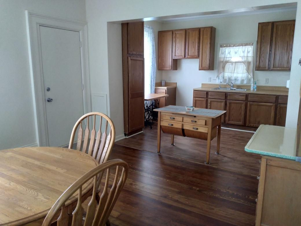 5122 North Bennett Road Monroe Center, IL 61052 - Photo 5 of 29 a kitchen with granite countertop a dining table chairs cabinets a sink and a window