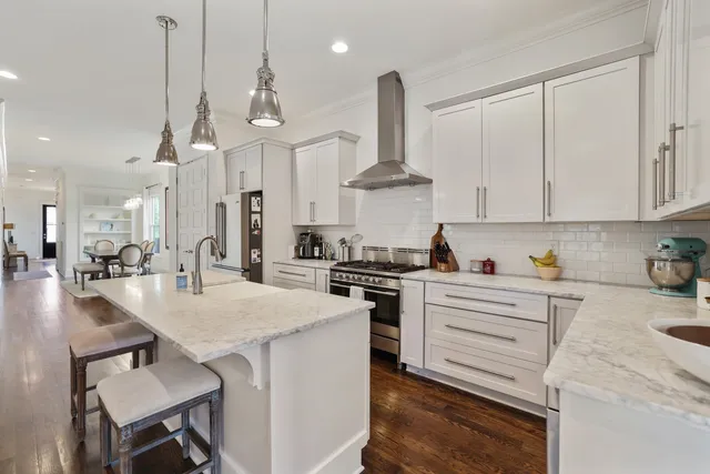 a kitchen with stainless steel appliances granite countertop a sink a stove and a wooden floors