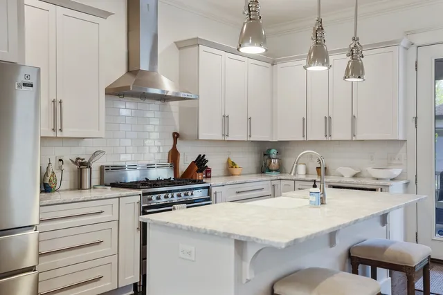 a kitchen with stainless steel appliances a sink a stove a refrigerator and cabinets