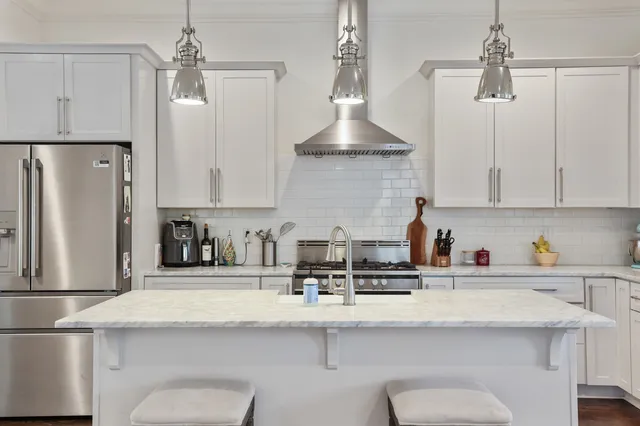 a kitchen with stainless steel appliances a sink a stove a refrigerator and cabinets
