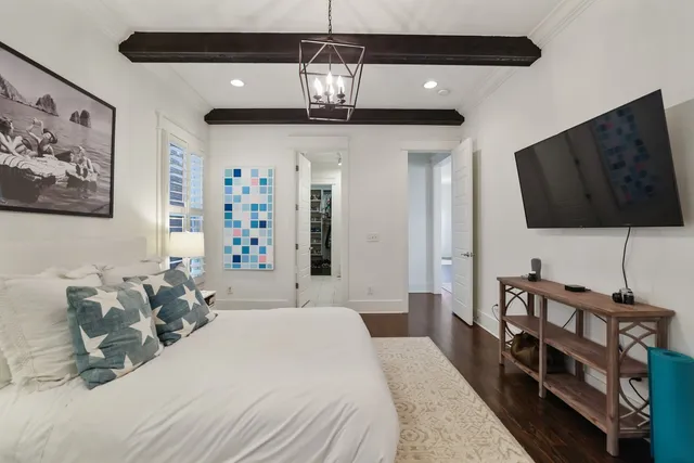 a bedroom with a bed window and a flat screen tv