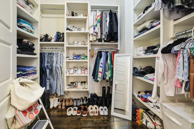 a view of walk in closet with clothes and shoes