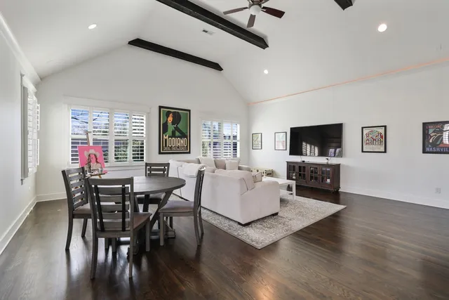 a living room with furniture a flat screen tv and a dining table with wooden floor