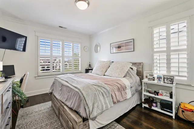 a bedroom with a bed a computer on desk and a window