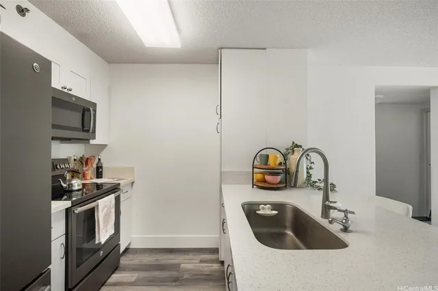 a kitchen with a sink and a stove top oven