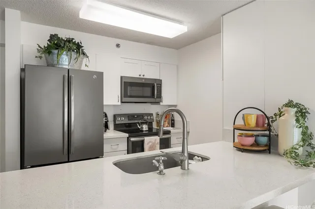 a kitchen with stainless steel appliances a refrigerator a stove a sink a microwave and cabinets