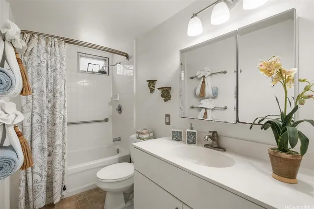 a bathroom with a sink a mirror a toilet and shower