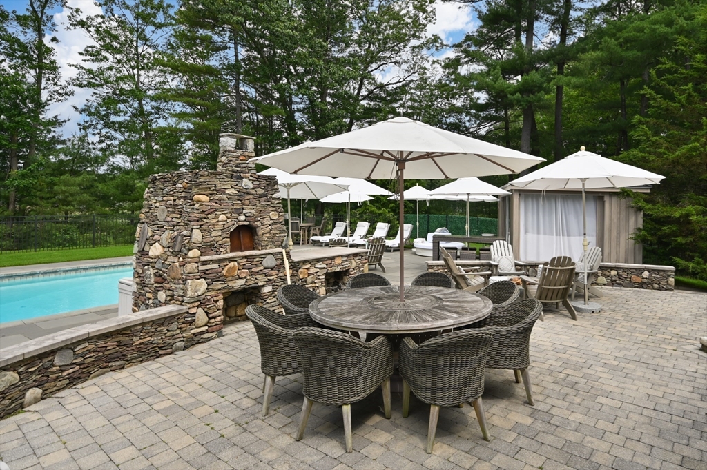 46 Baldpate Road Boxford, MA 01921 - Photo 30 of 42 a patio with a table and chairs under an umbrella