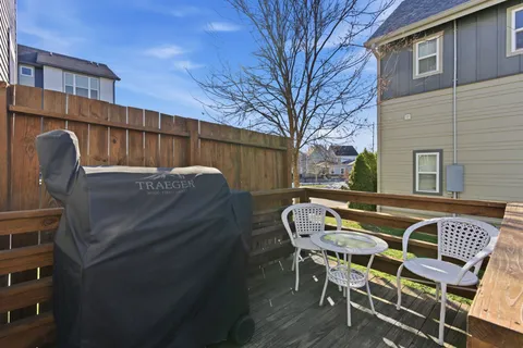 a view of backyard with table and chairs and wooden fence