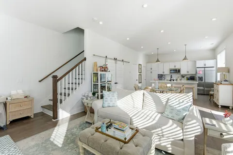 a living room with furniture and a view of kitchen