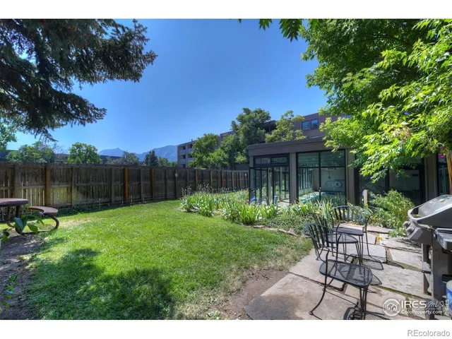a view of a chair and table in backyard of the house