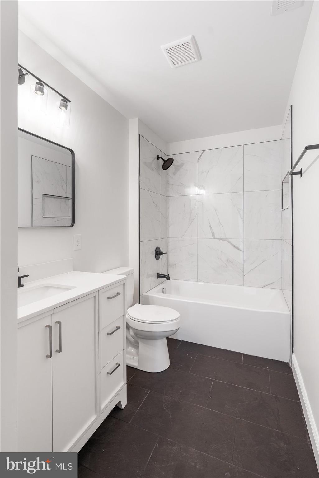 13101 Choptank Avenue Middle River, MD 21220 - Photo 19 of 27 a bathroom with a toilet a sink a mirror and a bathtub