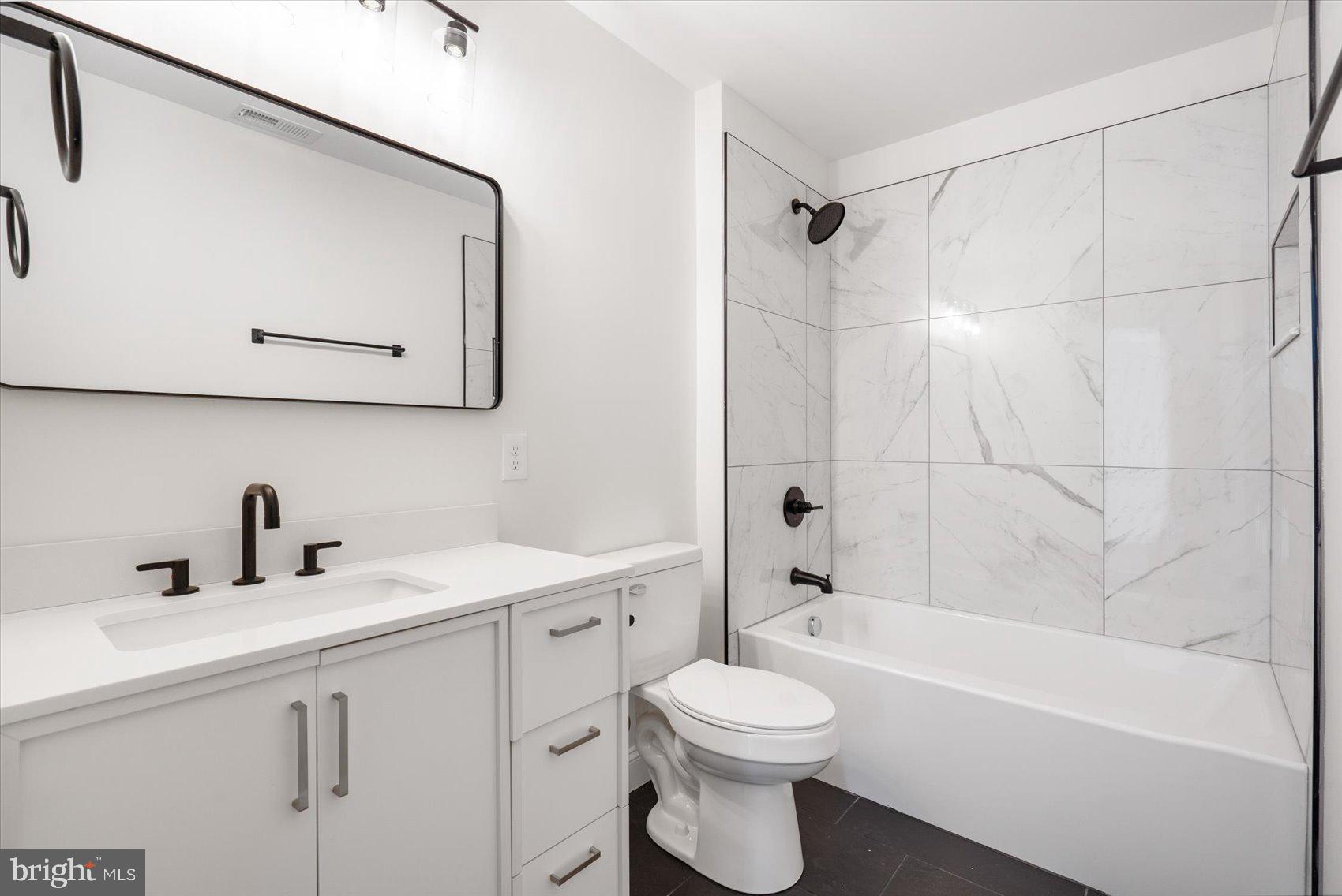 13101 Choptank Avenue Middle River, MD 21220 - Photo 20 of 27 a bathroom with a toilet sink vanity tub and shower