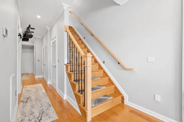 a view of a hallway with wooden floor and staircase