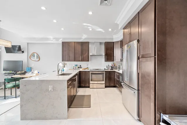 a kitchen with stainless steel appliances granite countertop a refrigerator stove and sink