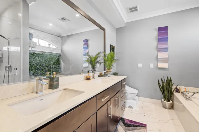 a bathroom with a sink a mirror and a potted plant