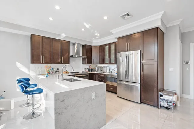 a kitchen with refrigerator and chairs