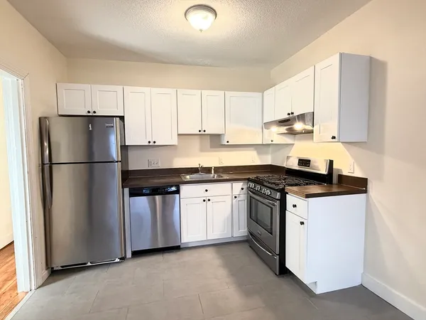 a kitchen with stainless steel appliances granite countertop a refrigerator stove a sink and a granite counter tops