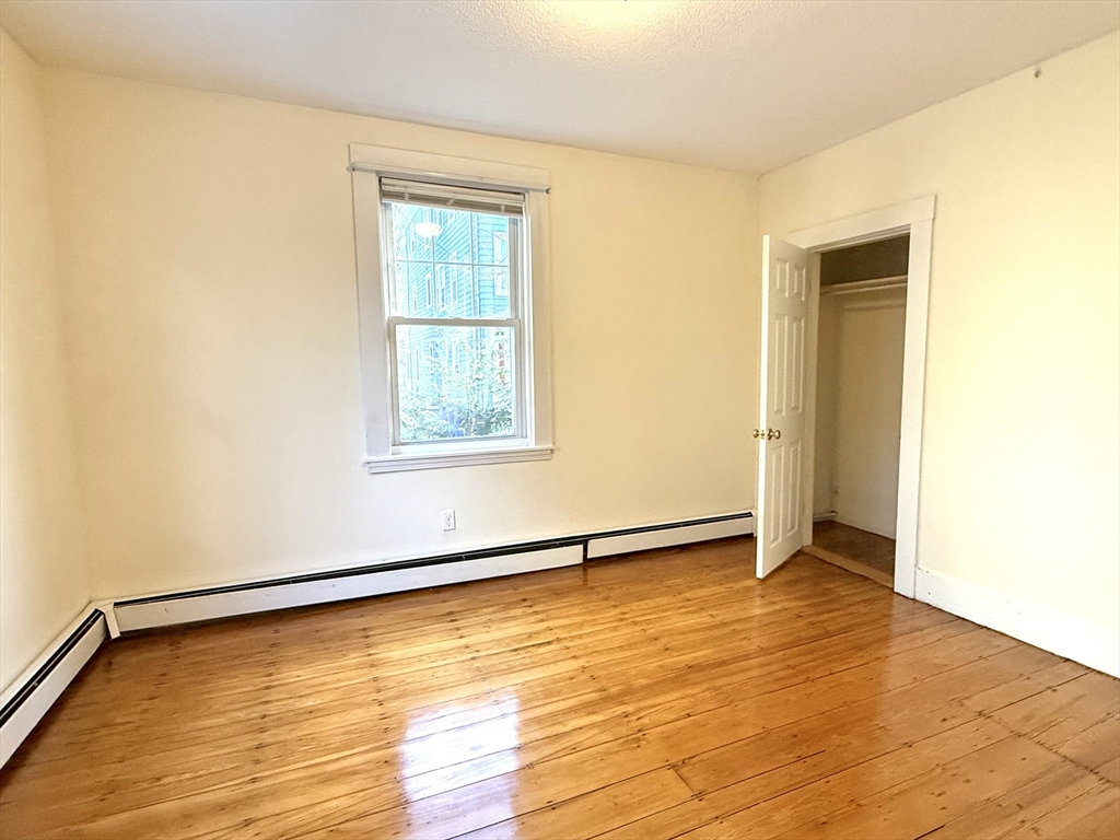 18 Roberts Street, Unit 1 Brookline, MA 02445 - Photo 6 of 10 a view of an empty room with wooden floor and a window