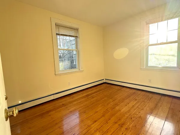 a view of a room with wooden floor and windows