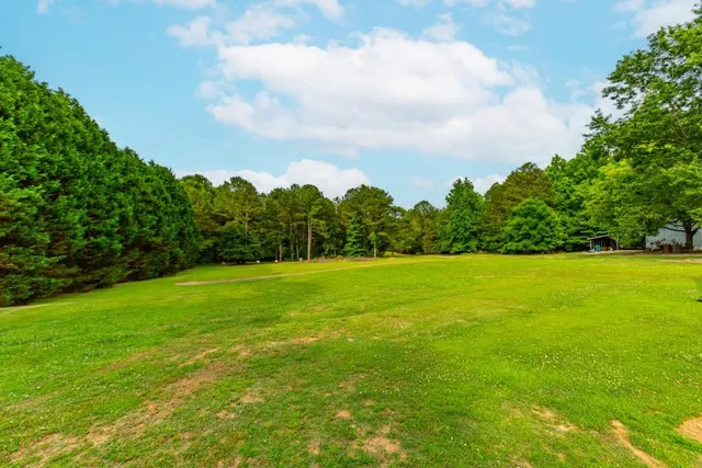 a view of a green field with wooden fence