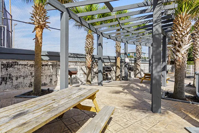 a view of a patio with table and chairs with wooden floor and fence