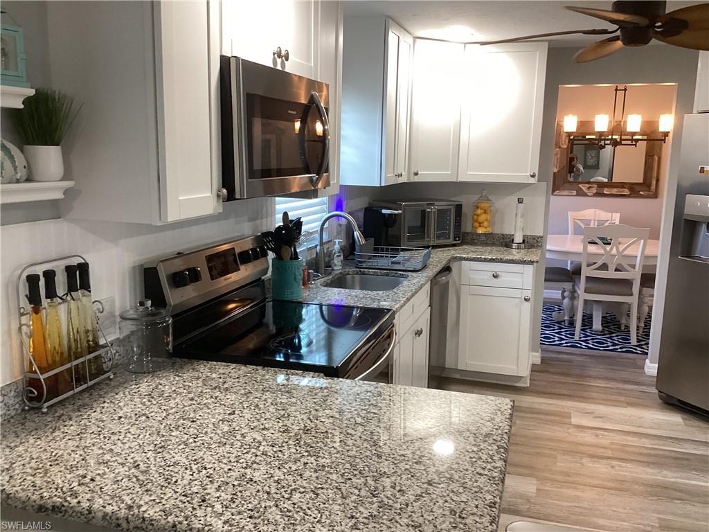 4 Chateau Way Naples, FL 34112 - Photo 12 of 45 a kitchen with stainless steel appliances granite countertop a stove sink and cabinets