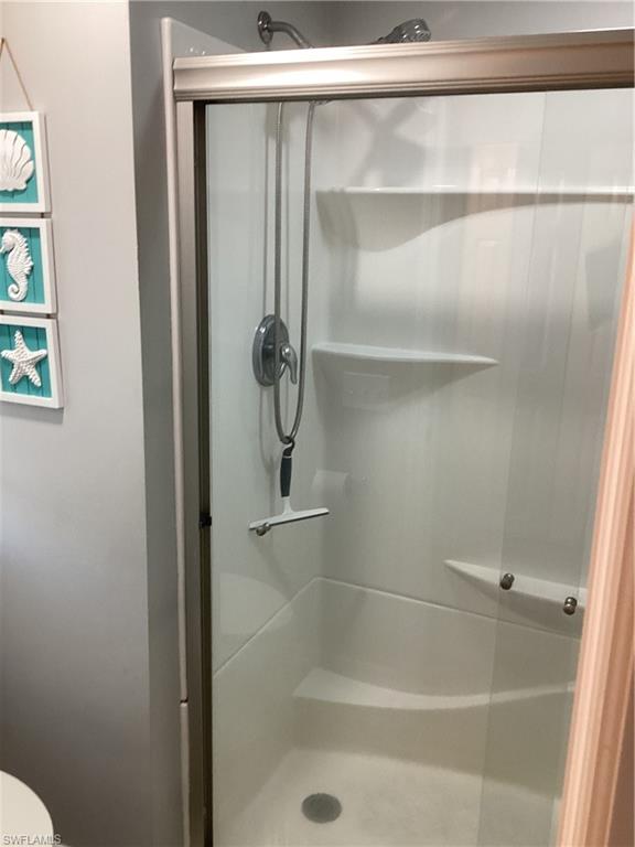 4 Chateau Way Naples, FL 34112 - Photo 20 of 45 a bathroom with a glass shower door