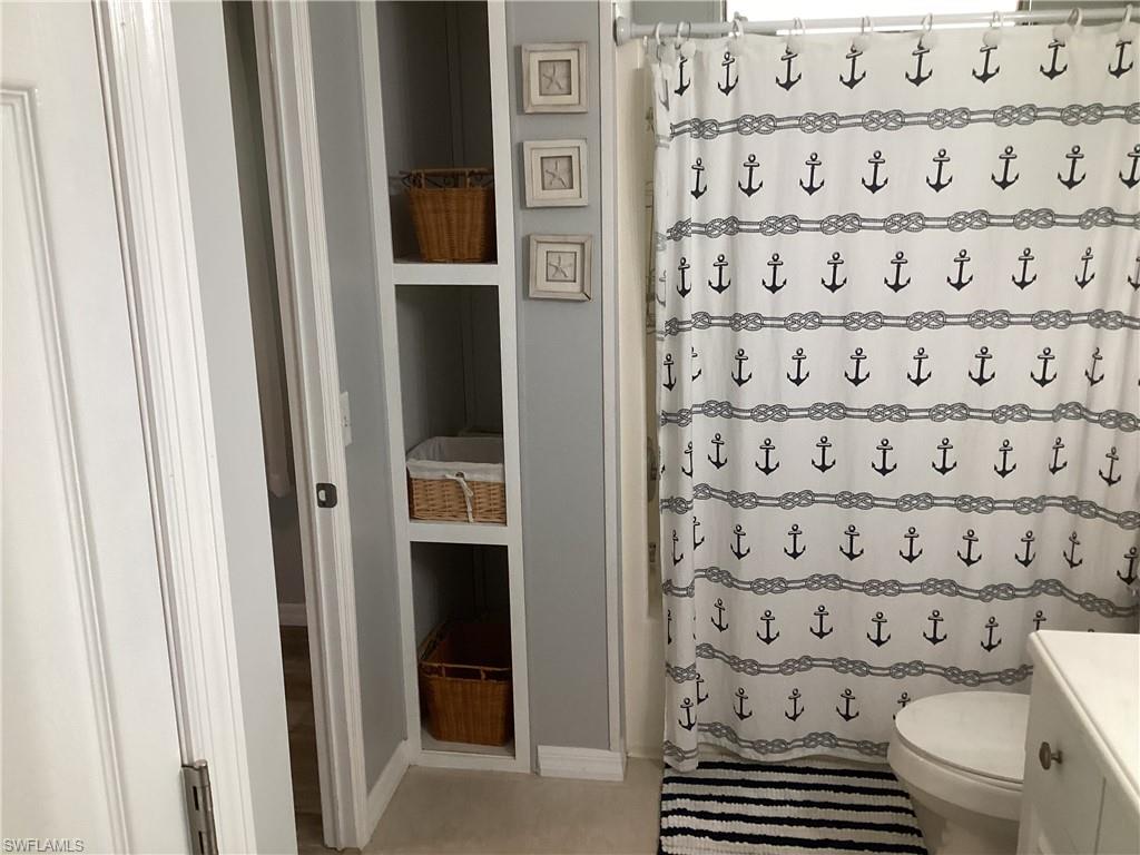 4 Chateau Way Naples, FL 34112 - Photo 24 of 45 a bathroom with a toilet and a shower curtain